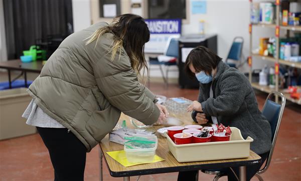 Teacher helps girl sort packets